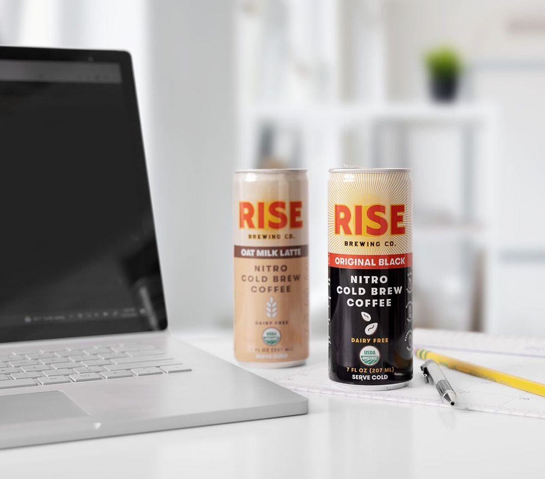 RISE Brewing Co. canned drink on counter next to laptop