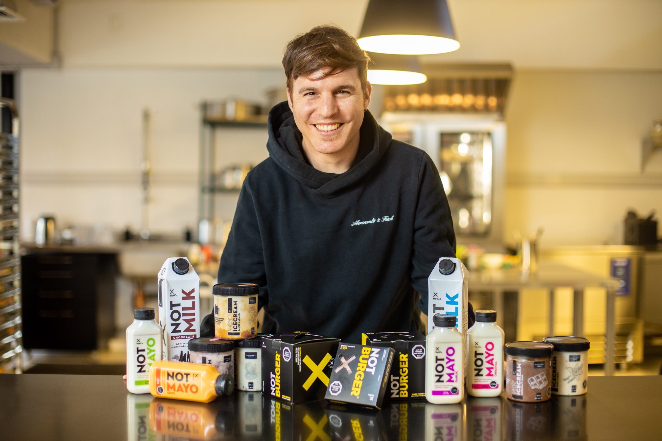 Founder standing in front of NotCo products