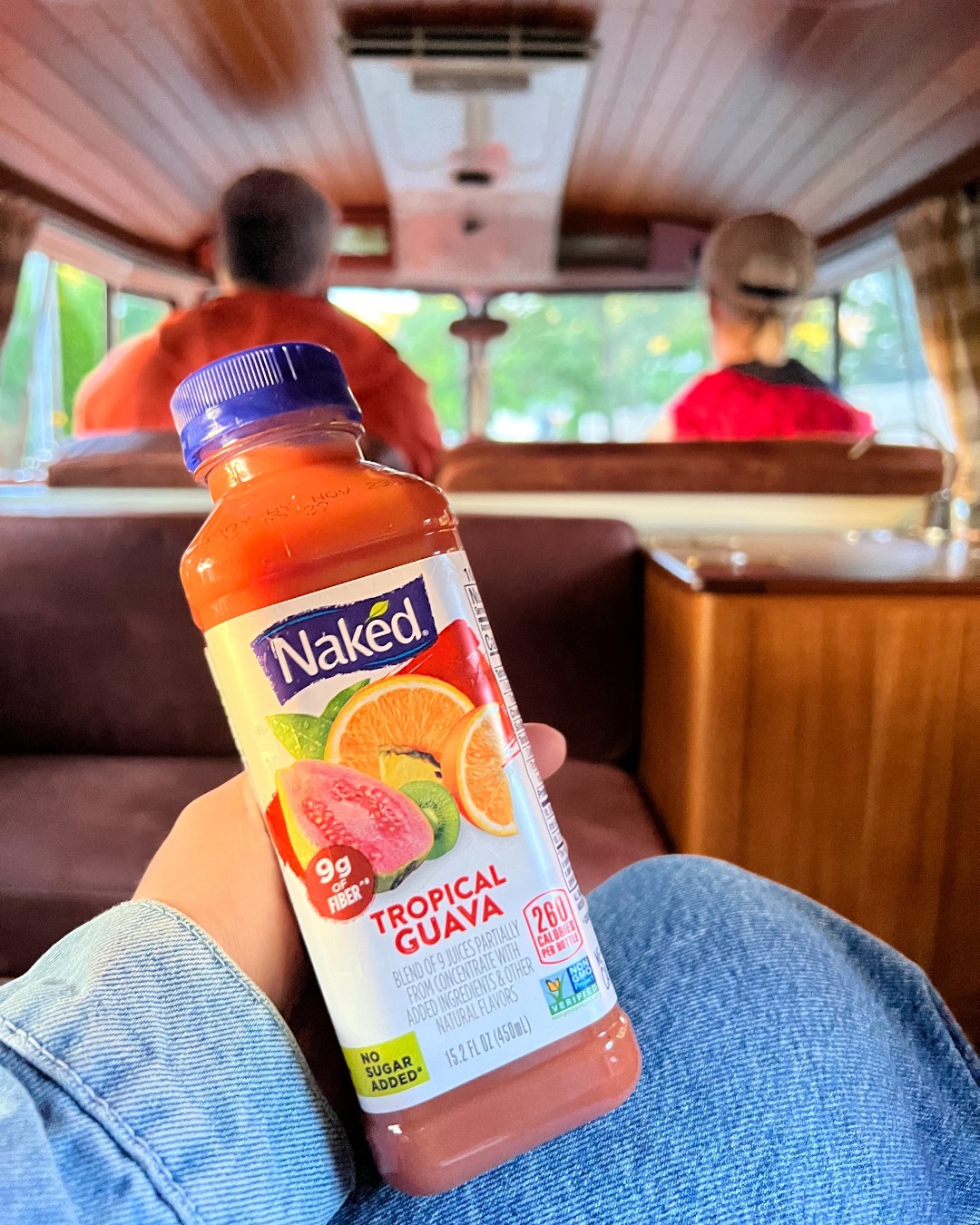 Person holding Naked juice in back of car
