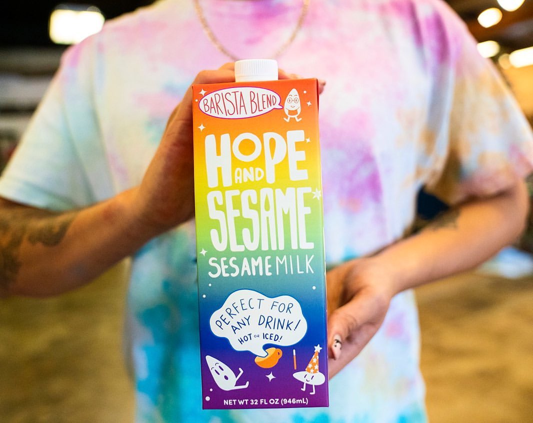 Person holding Hope and Sesame carton
