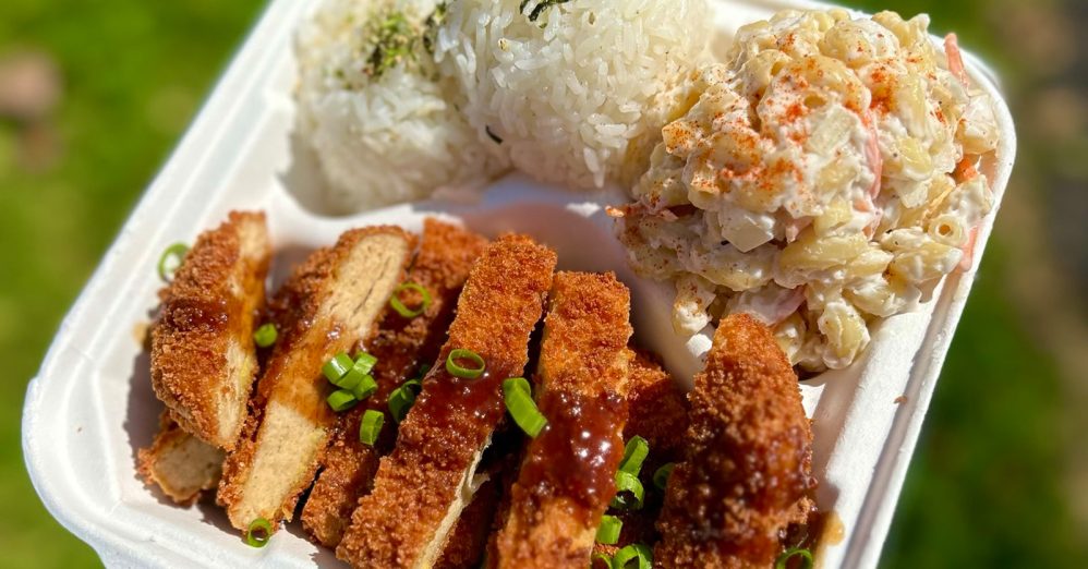 Person holding plate of vegan food from Lucky Catsu