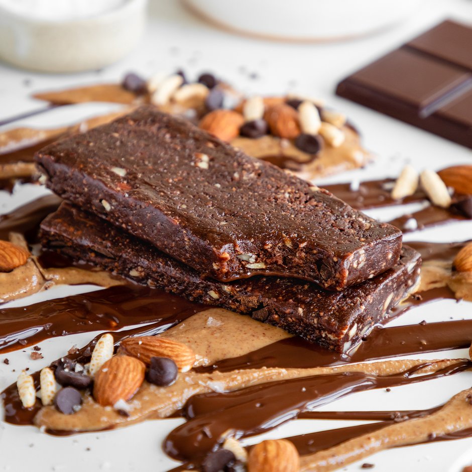 GoMacro bar laying on top of drizzled chocolate and peanut butter with almonds