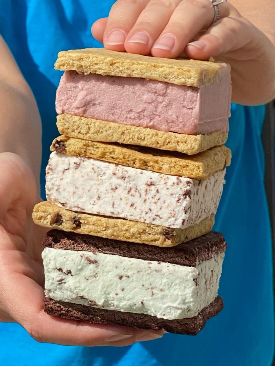 Person holding three Kula vegan ice cream sandwiches