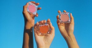 People holding Tower 28 products in the sky