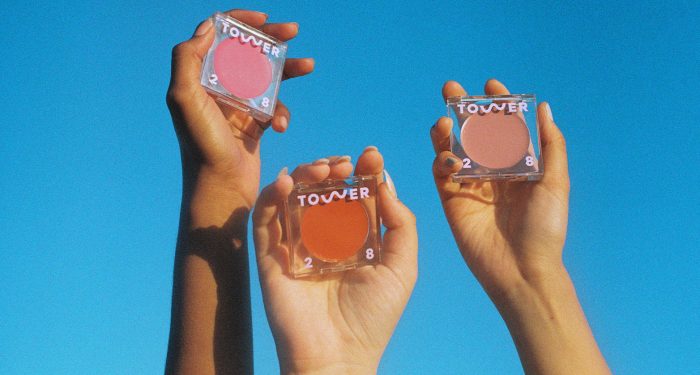 People holding Tower 28 products in the sky