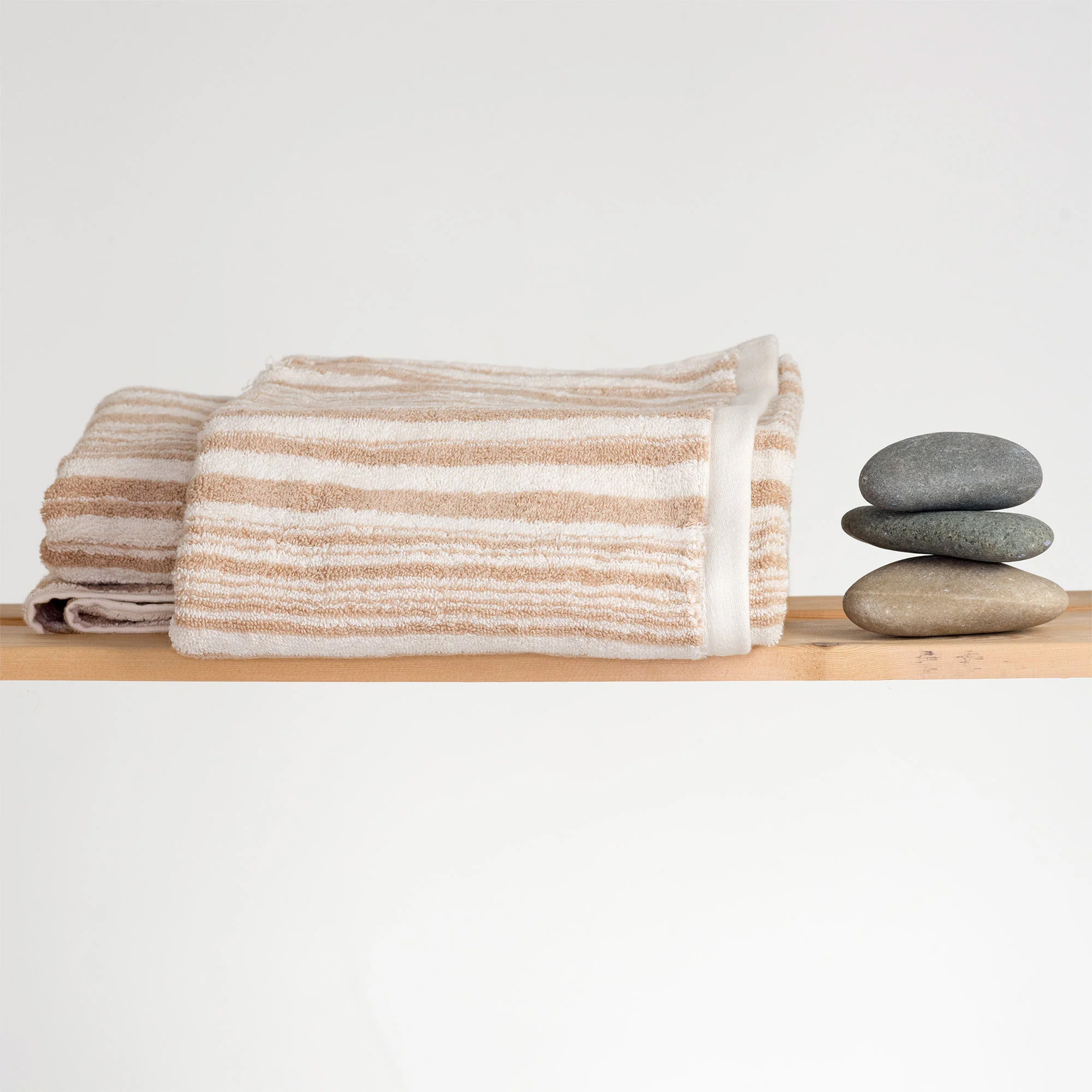 Rawganique towels on rack with rock