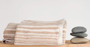 Rawganique towels on rack with rock