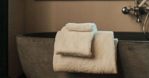 Anact towels sitting on side of bath tub