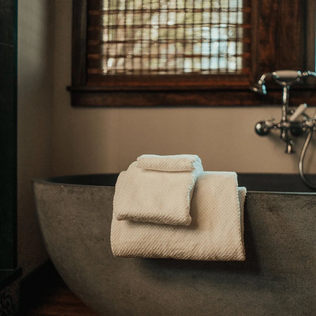 Anact towels sitting on side of bath tub