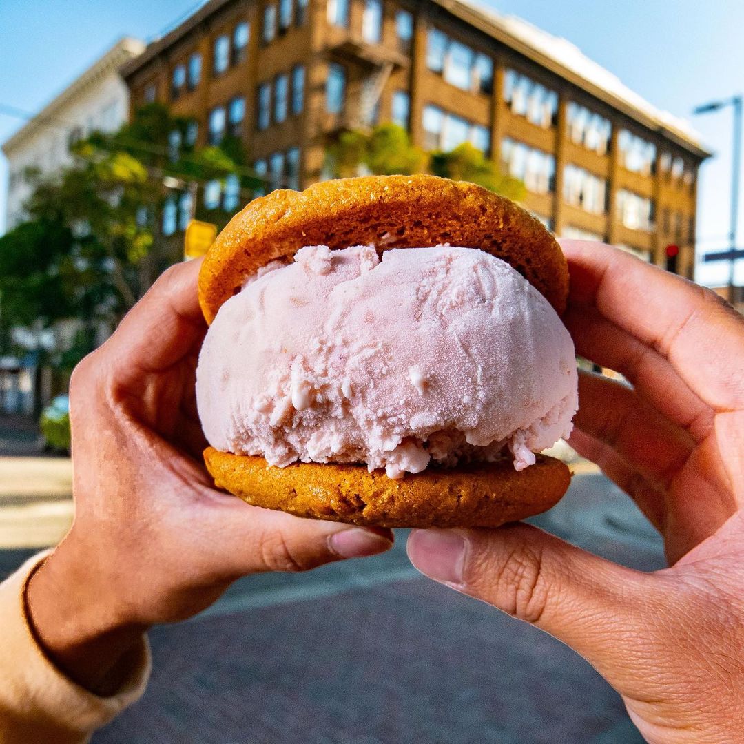 Person holding vegan ice cream sandwich from Cream