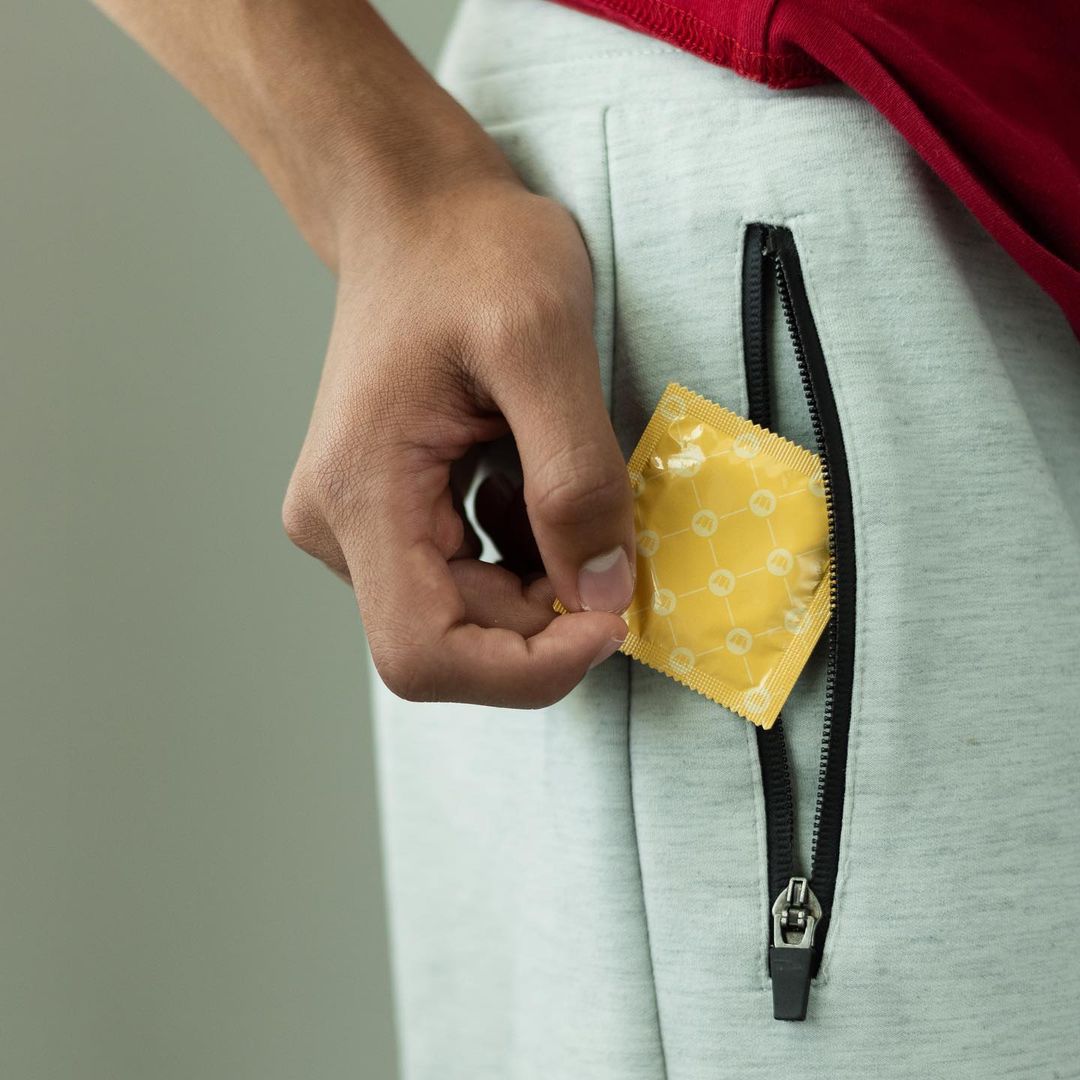 Person grabbing vegan condom from Royal Intimacy from pocket