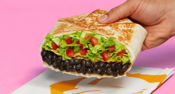 Person holding vegan Crunchwrap from Taco Bell