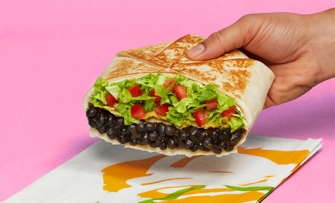 Person holding vegan Crunchwrap from Taco Bell