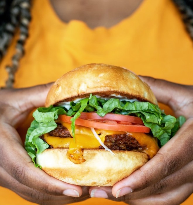 Person holding Trio Plant-Based vegan burger