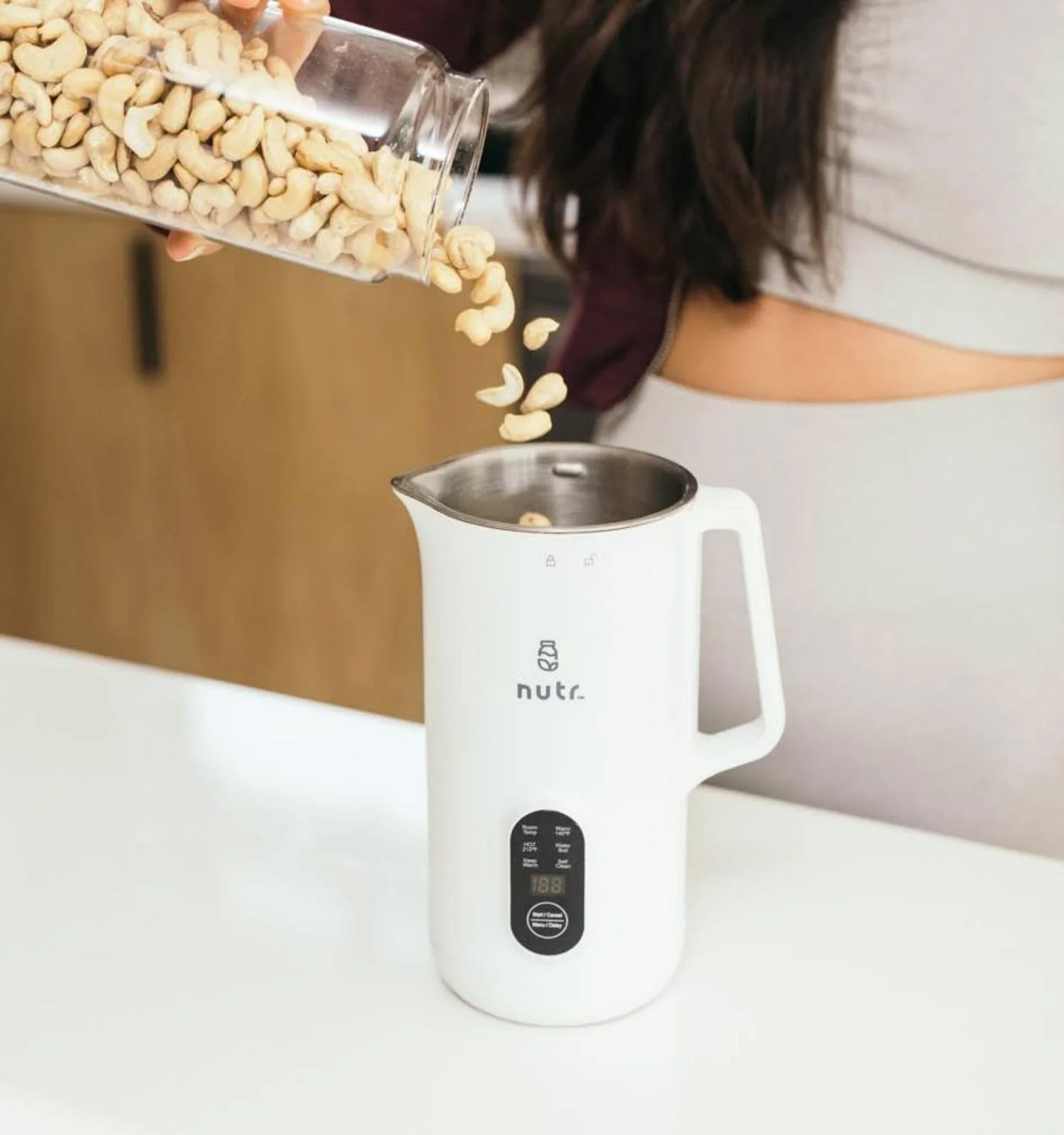 Person pouring nuts into Nutr machine