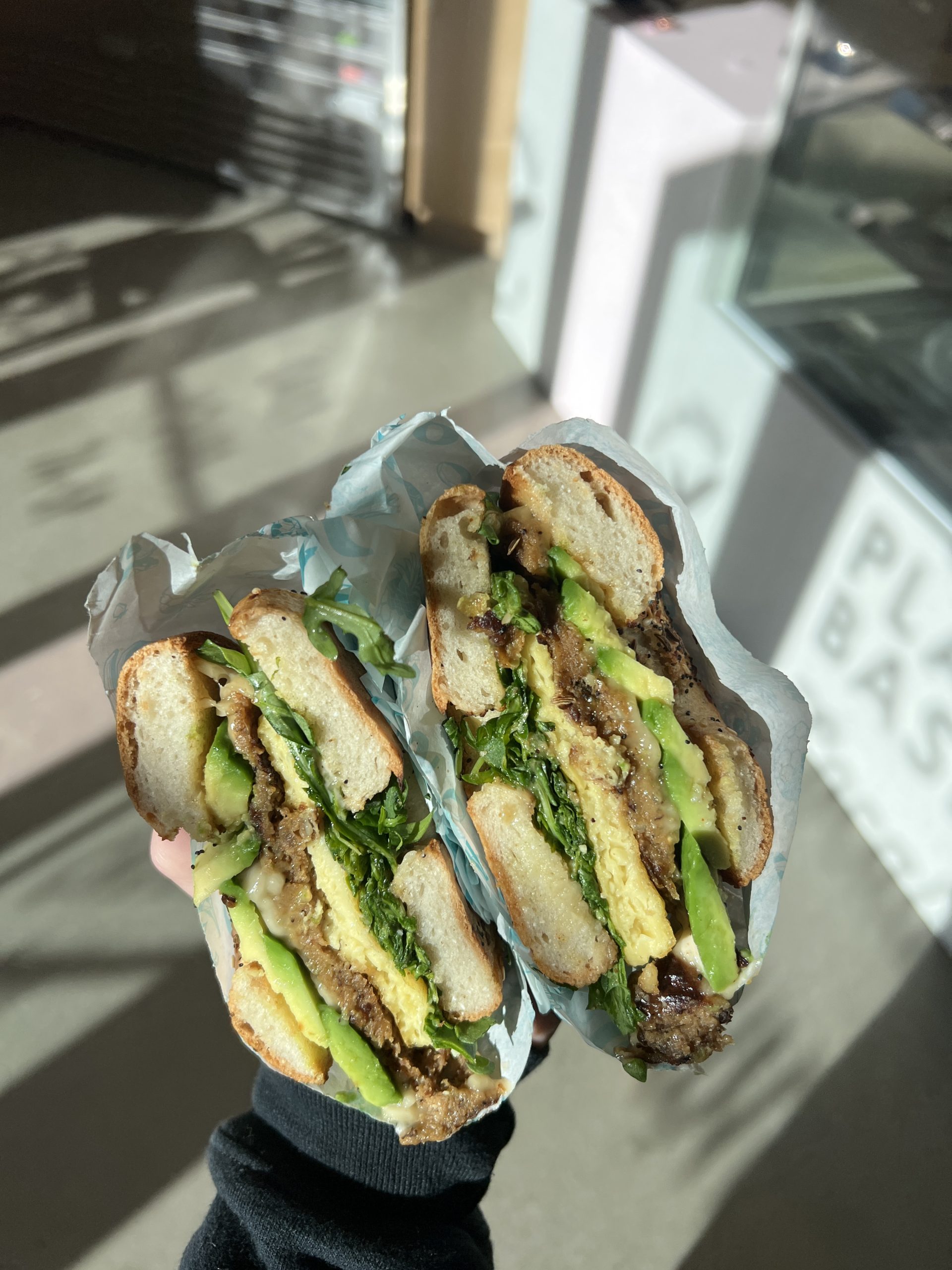 Person holding vegan sandwich from JOi cafe