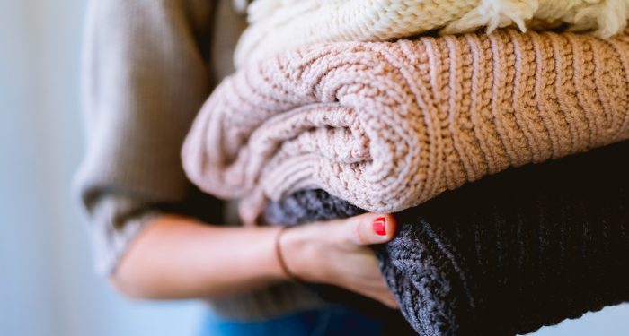 Photo of person holding sweaters