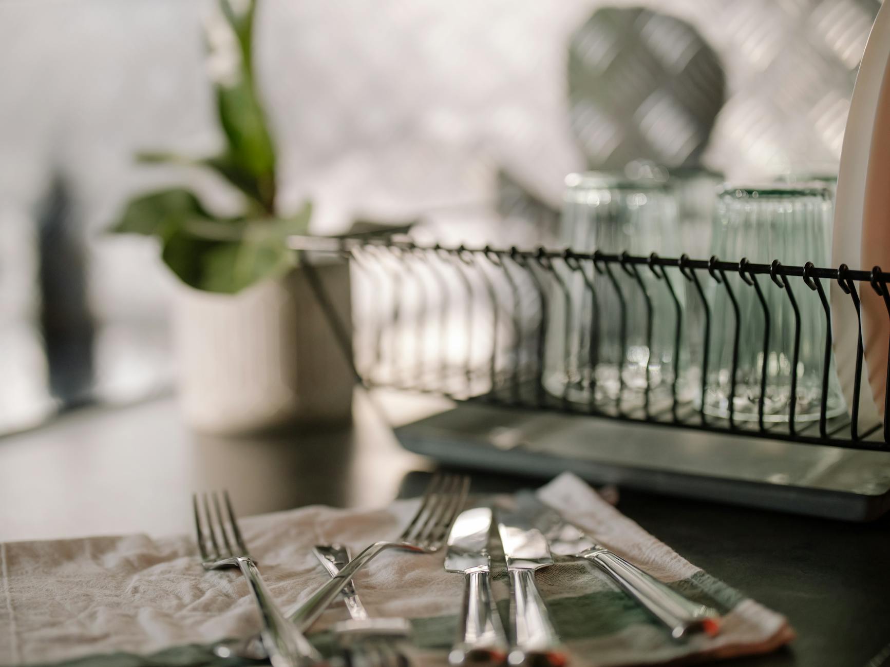 A beautifully arranged kitchen scene featuring cutlery, glasses, and modern kitchenware.