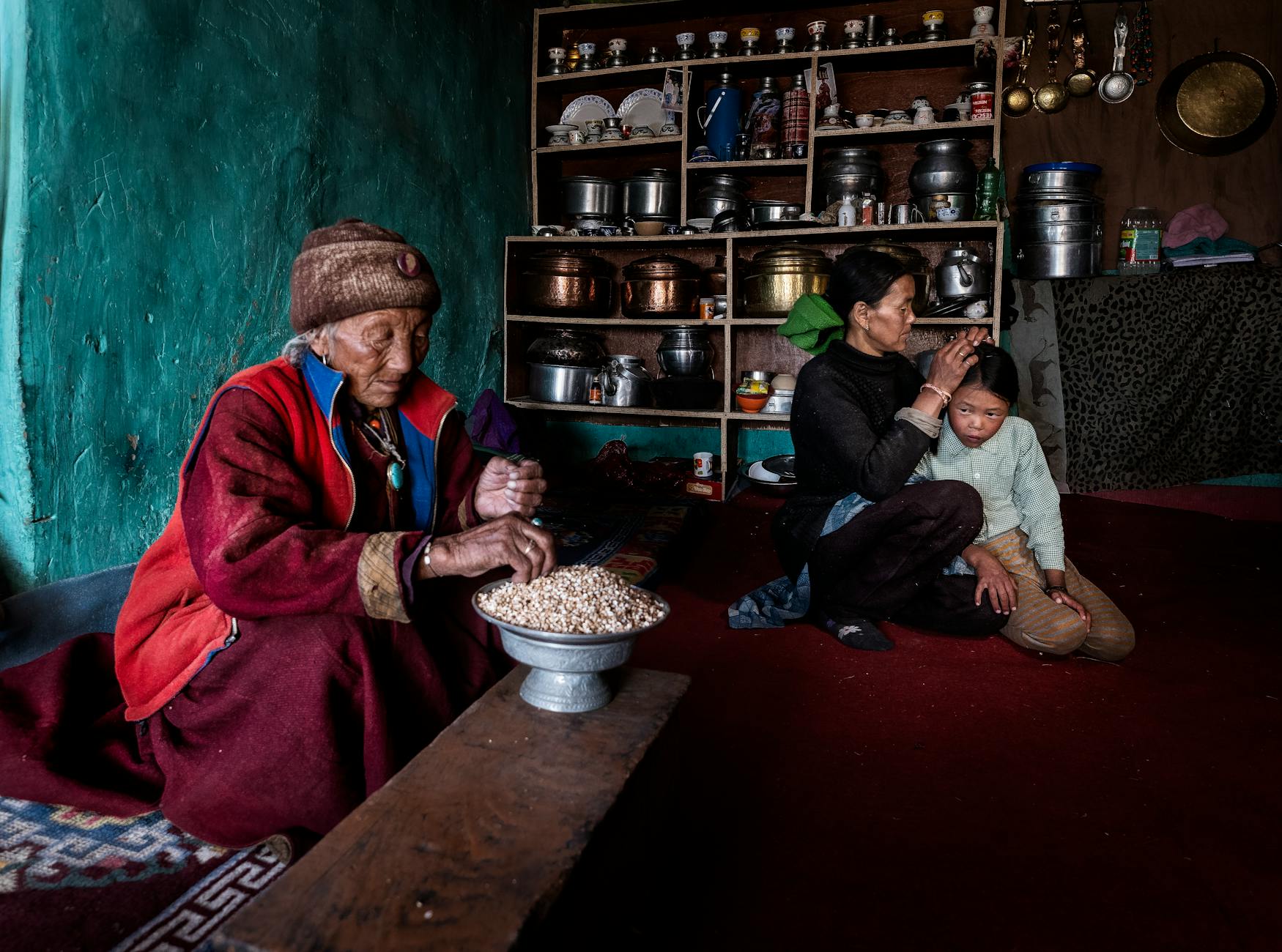 A cozy family scene in a rustic kitchen with an elderly woman and family members indoors.