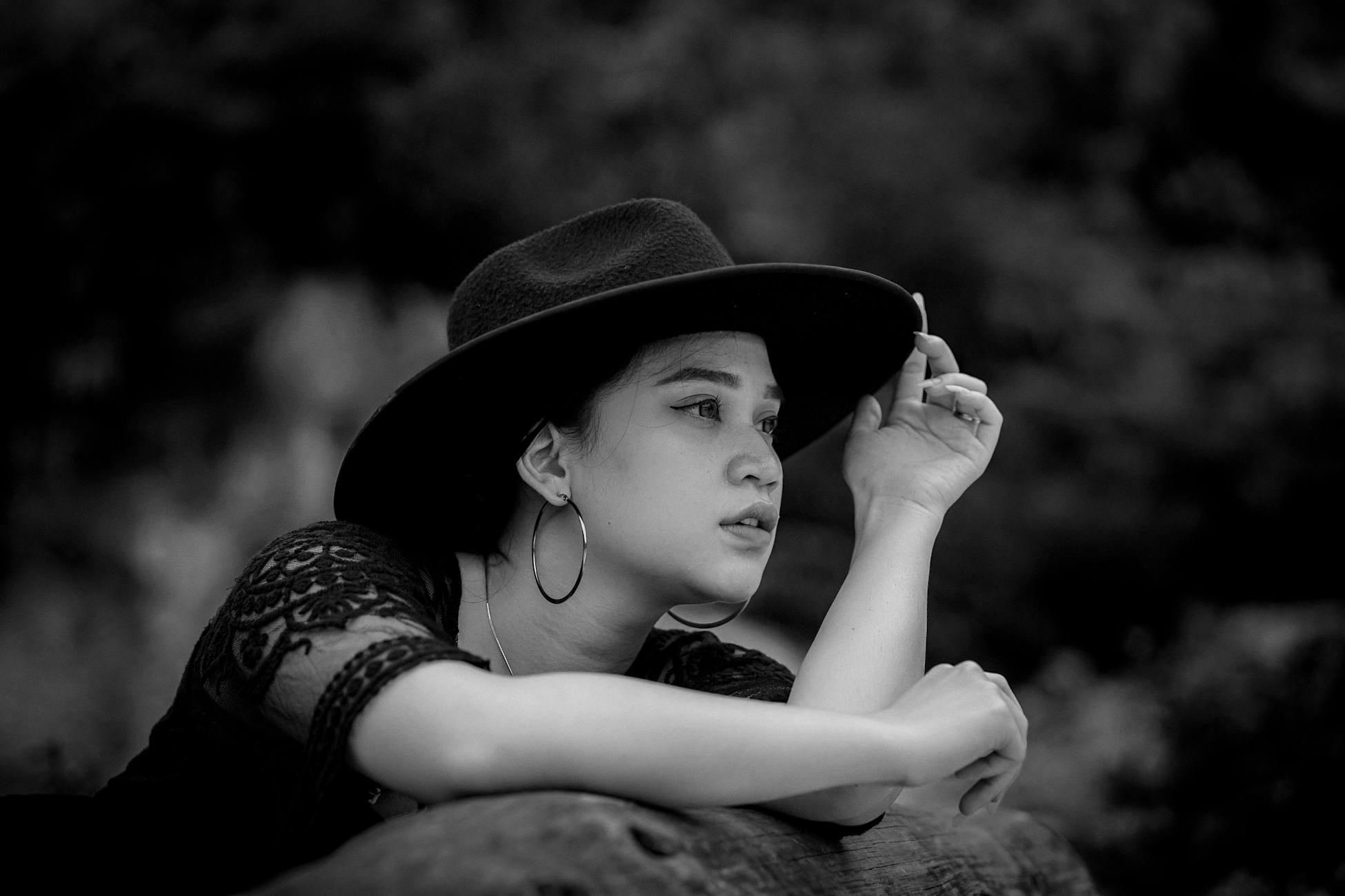 Black and white portrait of a woman in a stylish hat, evoking elegance and glamour.