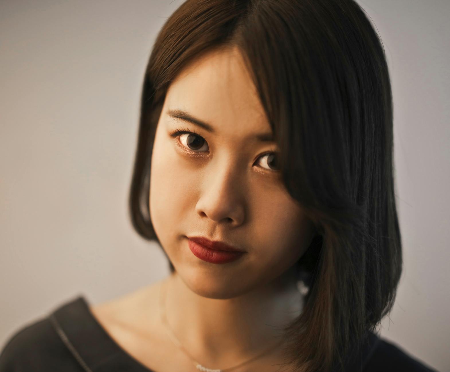 Intimate close-up portrait of a woman with expressive eyes indoors.