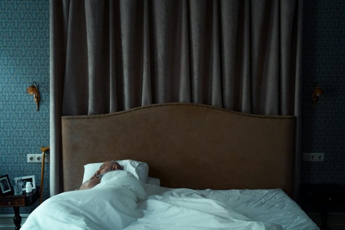 A serene bedroom with a man sleeping, evoking a sense of tranquility and comfort.