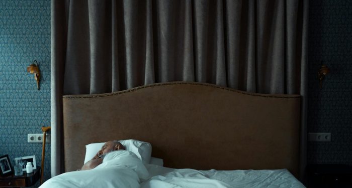A serene bedroom with a man sleeping, evoking a sense of tranquility and comfort.