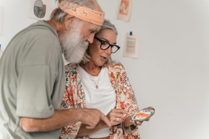 Elderly couple exploring a creative project together indoors.