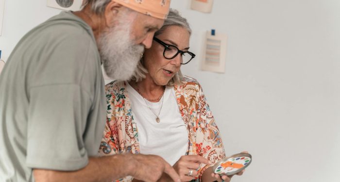 Elderly couple exploring a creative project together indoors.