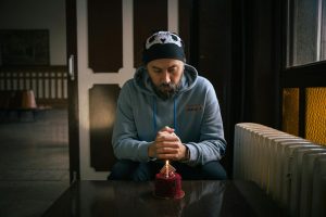 A man reflects on his birthday with a cake at a cozy indoor setting in Istanbul.