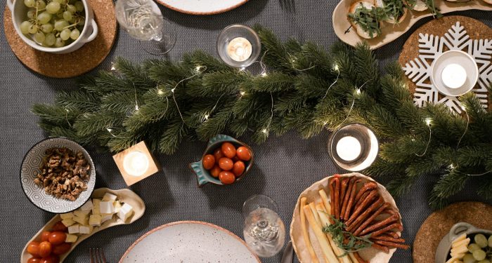Aerial view of a holiday dinner table with festive decorations and assorted appetizers.