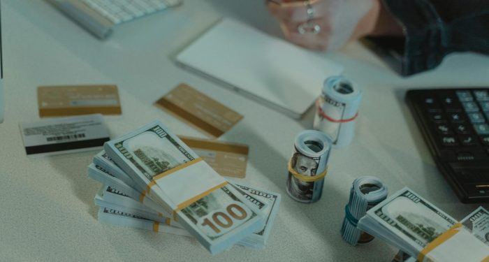 Close-up of dollar bills and credit cards on a desk, symbolizing financial transactions.