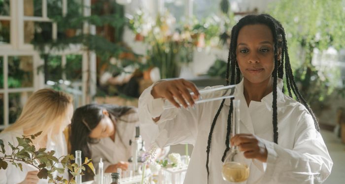 A diverse team of scientists in a botanical lab conducting experiments with plants and test tubes.