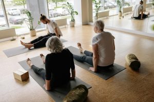 Adults participating in a relaxing yoga session in a serene studio environment.