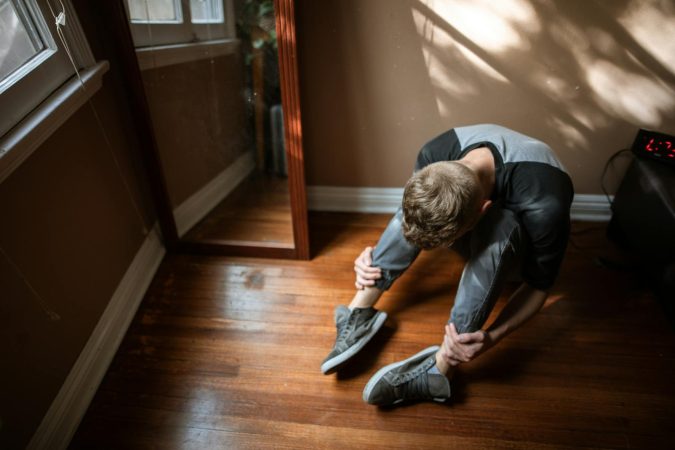 Man sitting on the floor alone, reflecting on life choices and regret in his 40s