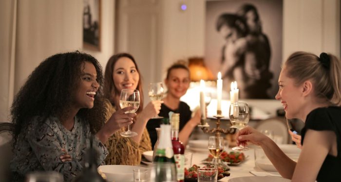 Women laughing together at dinner gathering