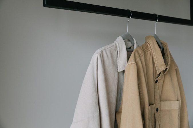 Close-up of beige shirts on hangers, showcasing minimalist style