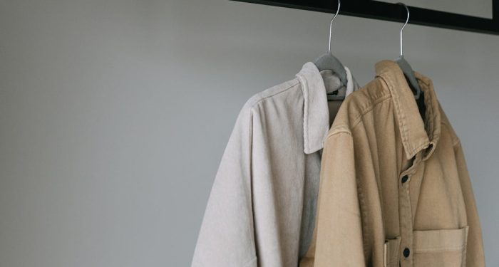 Close-up of beige shirts on hangers, showcasing minimalist style
