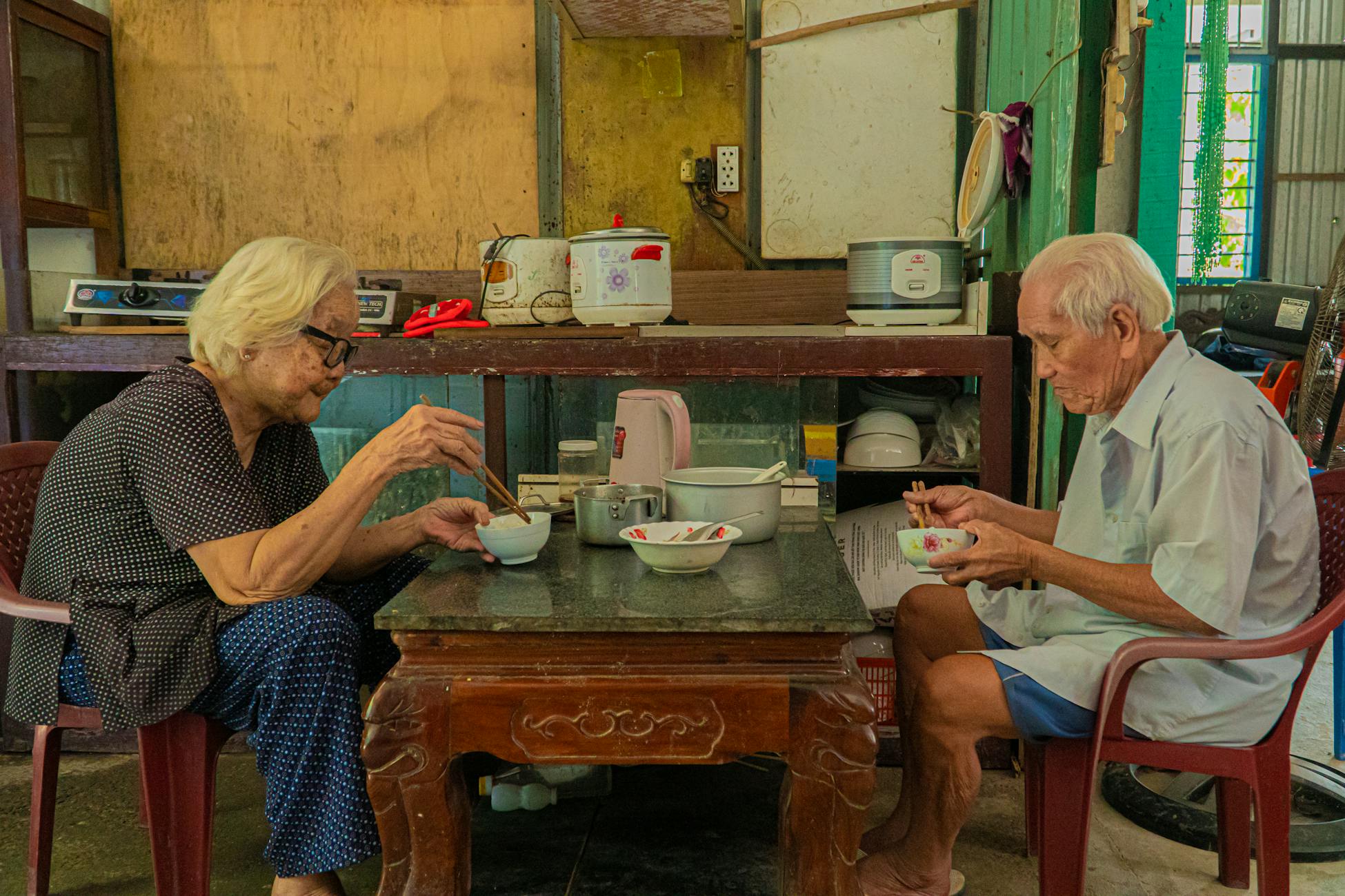 Senior couple having a meal together at their cozy home, highlighting warmth and companionship.
