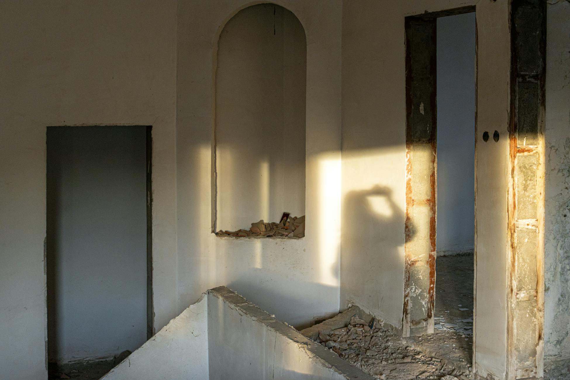 Moody sunlight casting shadows inside an abandoned building.