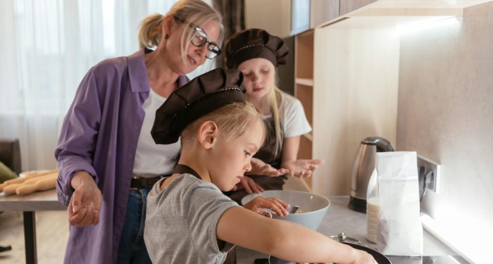 A family cooking together with children and a grandmother in a cozy kitchen.
