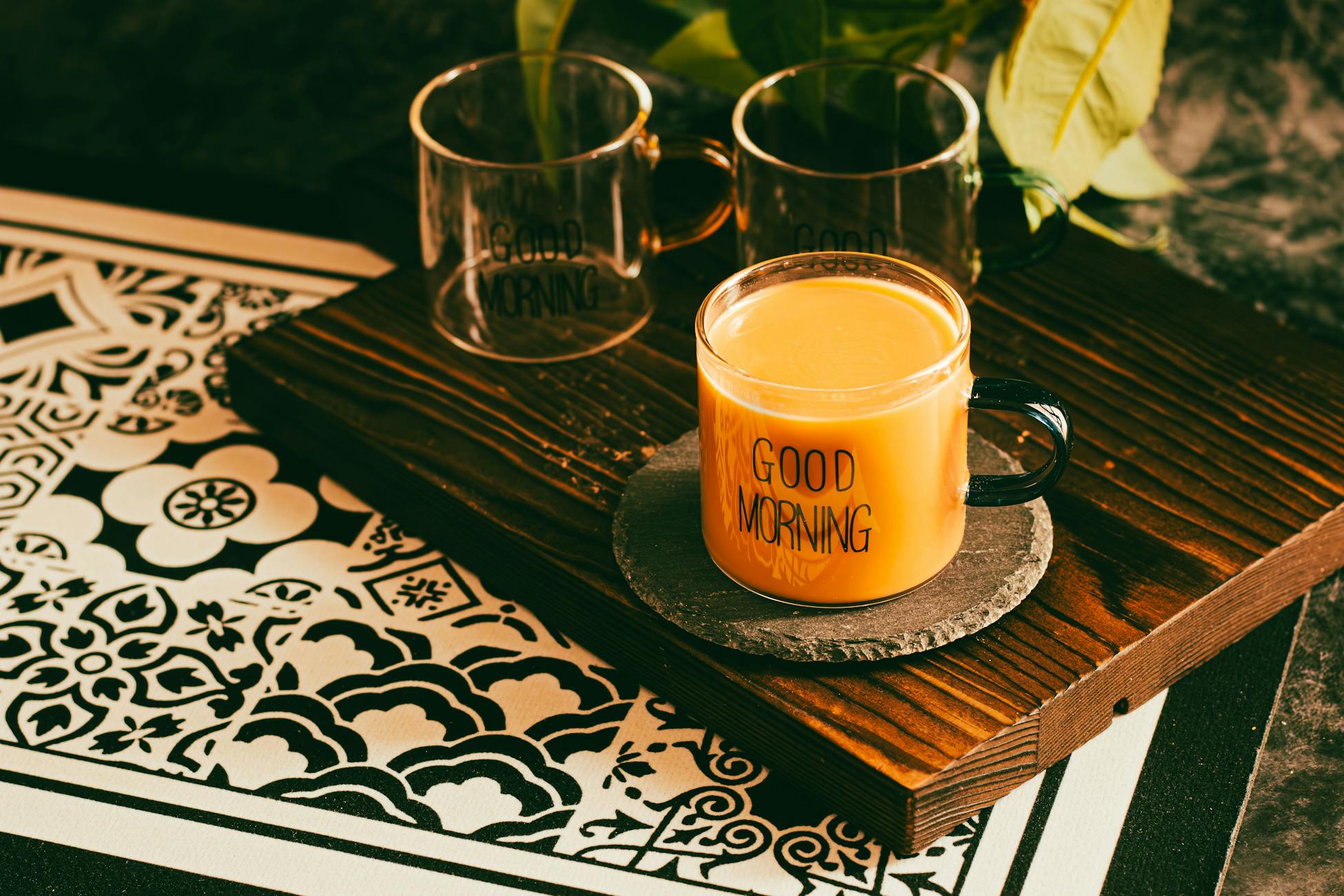 A warm mug of coffee with 'Good Morning' text on a decorative table setting.