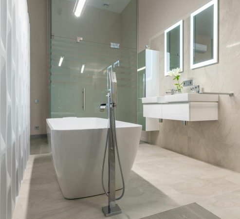 A chic and contemporary bathroom featuring a freestanding tub and elegant fixtures.