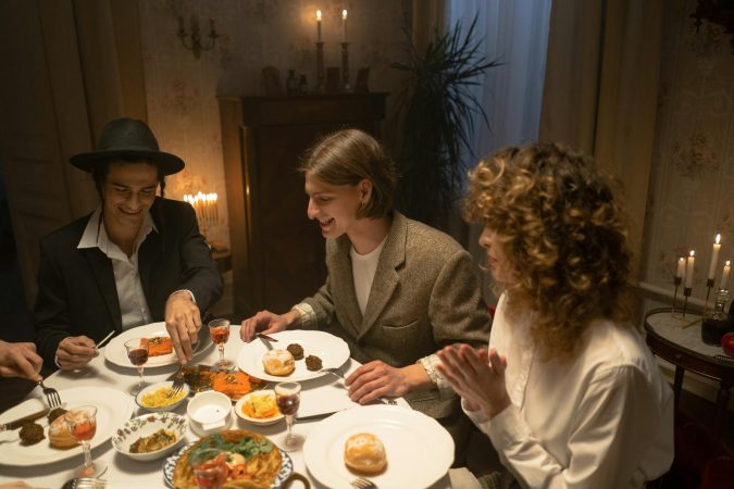 A festive indoor gathering with family sharing a traditional meal by candlelight.