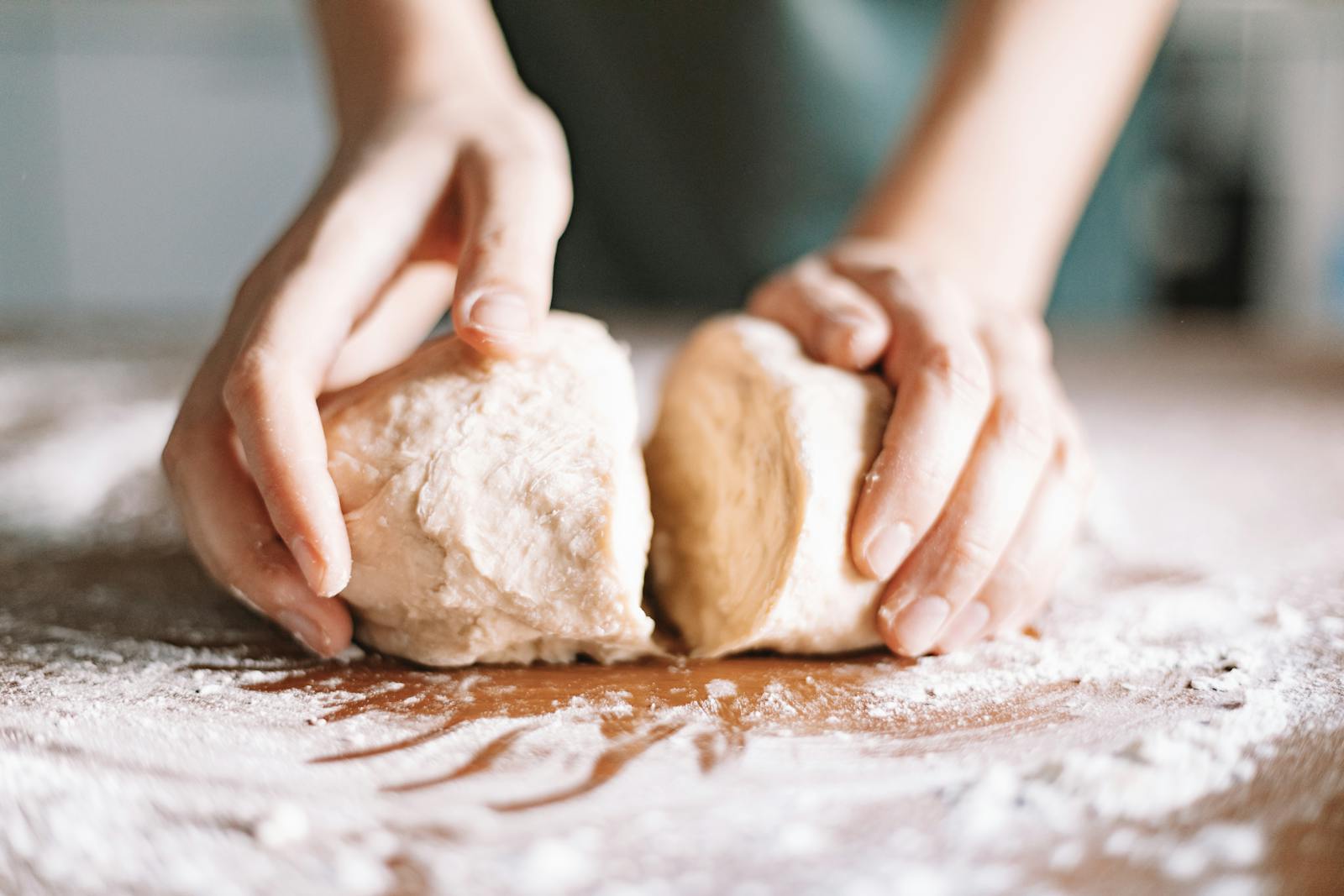 hands kneading bread dough close-up