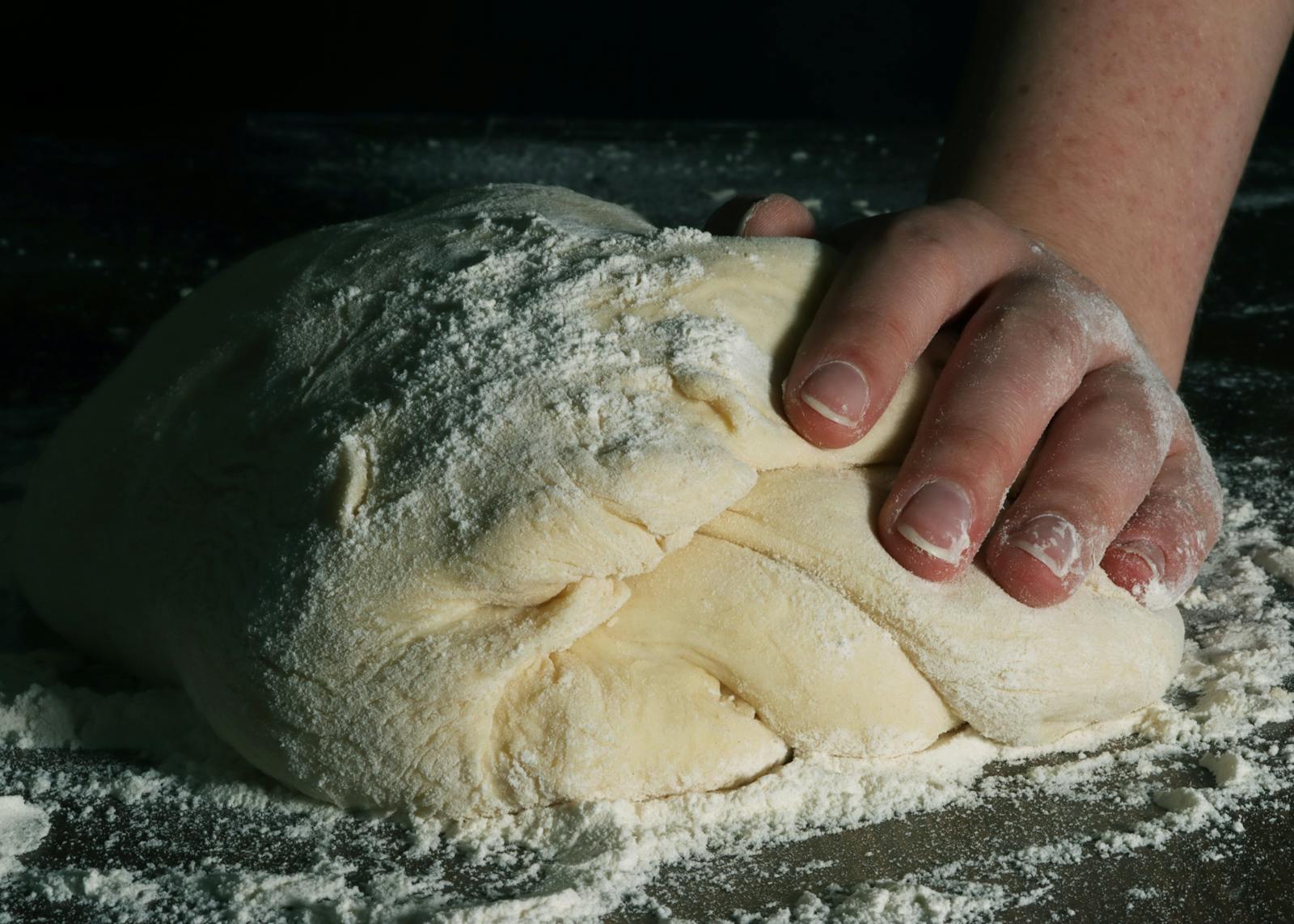 hands kneading bread dough