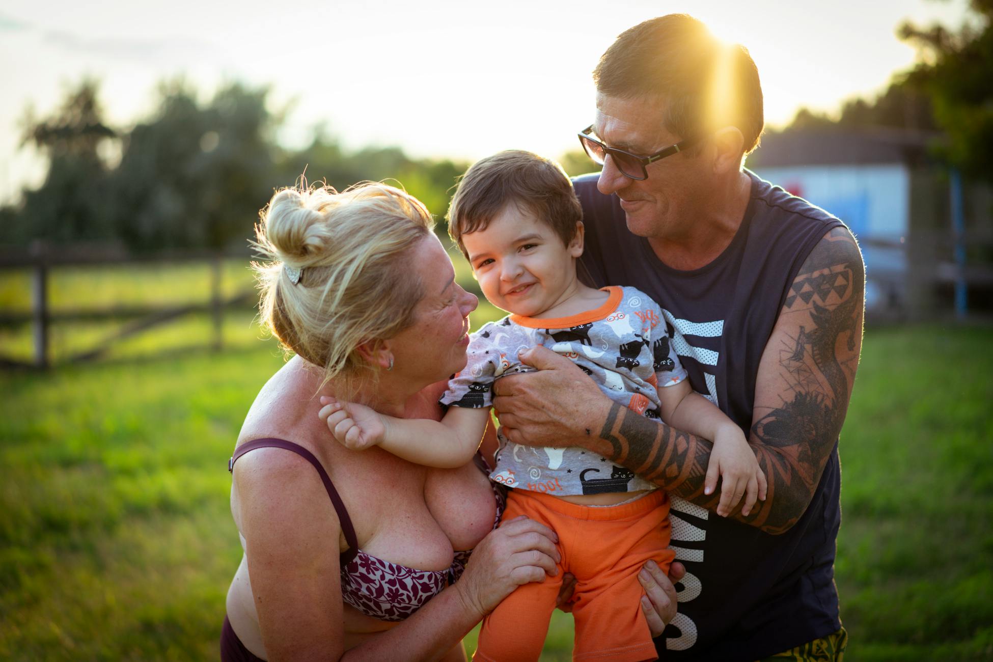 A happy family enjoying a sunny day outdoors with grandparents and grandson smiling.