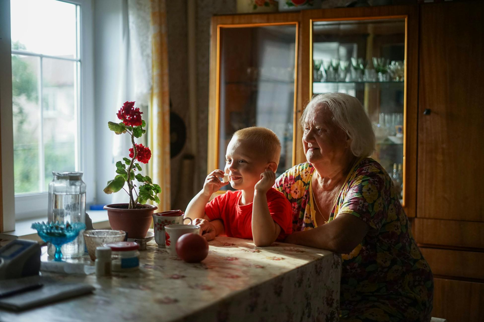 A touching moment of a grandmother and grandson enjoying each other's company indoors.