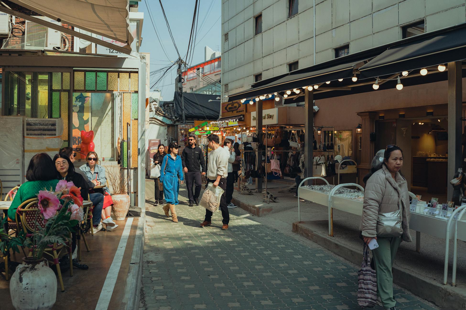 People enjoying a sunny day in Seoul's vibrant shopping streets, showcasing Korean lifestyle and culture.