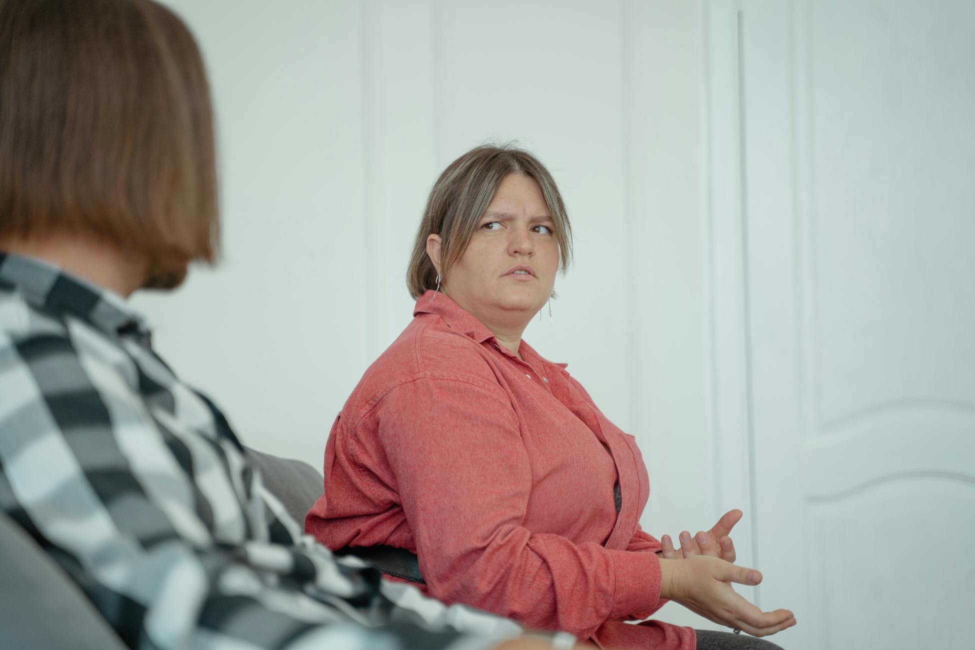 Two adults having a serious conversation indoors, showcasing emotions.